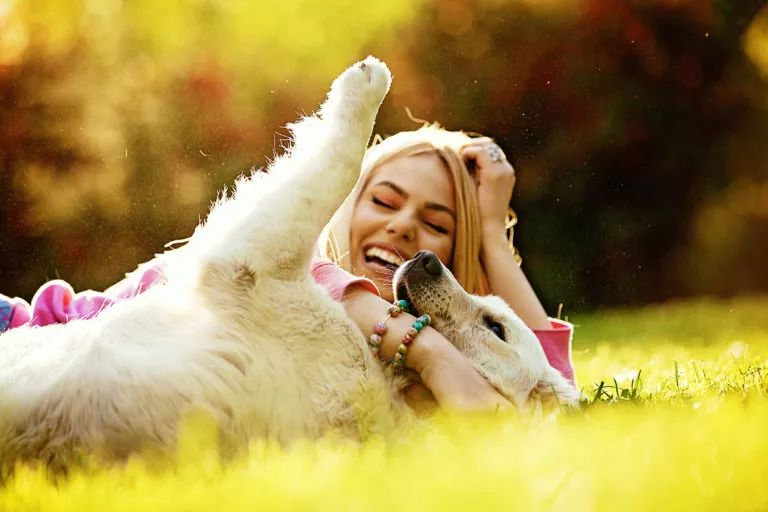 hund og dame lekende i parken