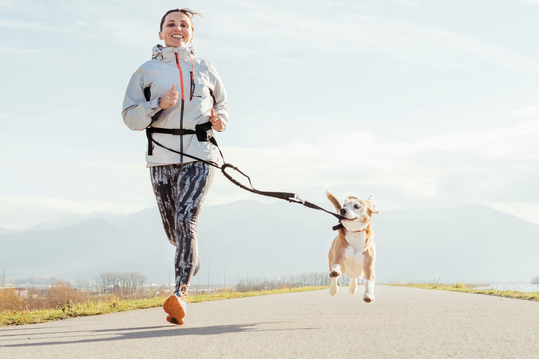 Kvinne som jogger med hund på joggebånd